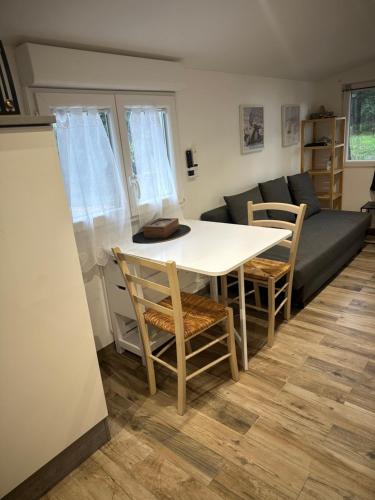a living room with a table and chairs and a couch at La maisonnette de Chantecoucou in Le Cannet-des-Maures