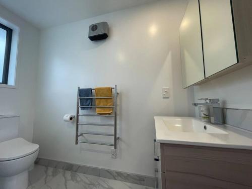 a white bathroom with a toilet and a sink at Parkside Retreat - 3 Beds -Sleeps 6 Near Westfield in Christchurch
