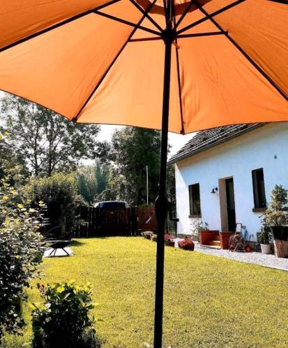 an orange umbrella in front of a house at Haus am Wiesengrund in Klein Strömkendorf
