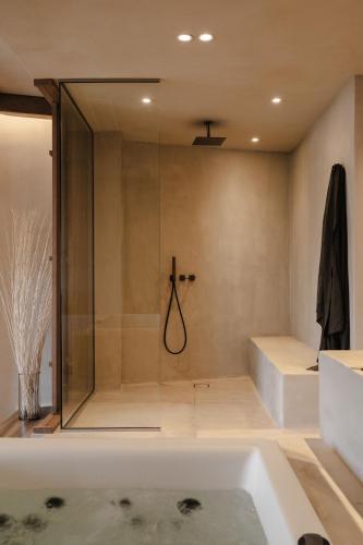 a bathroom with a shower and a bath tub at Tesoro Elegant escapes- suites in Naxos Chora