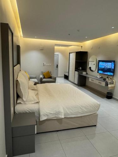 a bedroom with a large bed and a living room at فندق حياة حقل الفندقية Hayat Haql Hotel in Al Humaizah