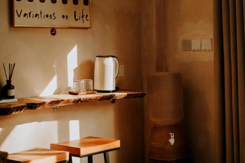 a kitchen with a coffee maker on a shelf at NYLA Boutique Resort Siargao in General Luna