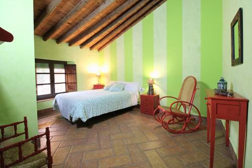 a bedroom with a bed and a desk and a chair at Casa de la Jara by SIERRA VIVA in La Nava
