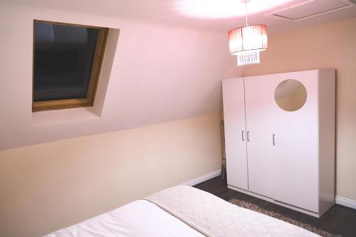 a bedroom with two beds and a cabinet and a television at F&Fs in Nuneaton