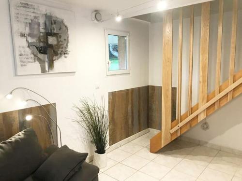 un salon avec un canapé et un escalier dans l'établissement Entre nous à la Riviera des Alpes, à Aix-les-Bains