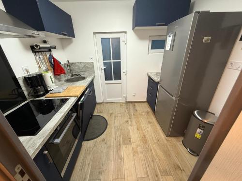 une cuisine avec des appareils électroménagers en acier inoxydable et des armoires bleues dans l'établissement La petite maison spécial, à Wimereux