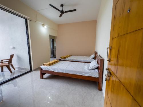 a bedroom with a bed with a ceiling fan at Punekar Bhavan in Akalkot