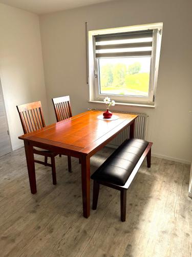 a dining room table with two chairs and a window at Ferienwohnung Anita in Jandelsbrunn
