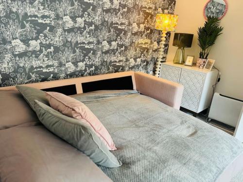 a bed with two pillows and a wall at Gorge Nest in Cheddar Gorge in Cheddar