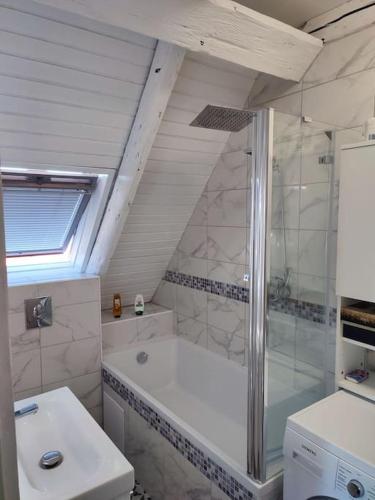 une salle de bain avec douche et lavabo dans l'établissement duplex aux portes de Strasbourg tram 100m, à Schiltigheim