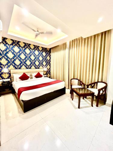 a bedroom with a bed and a table and a chair at Hotel Lycoris Zirakpur Chandigarh !! Main Highway Hotel ! Lift ! Large Parking ! Premium AC Rooms ! Traveler choice in Zirakpur
