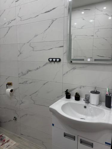 a white bathroom with a sink and a mirror at Stan na dan Loznica in Loznica