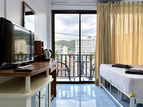 a hotel room with a bed and a balcony at Mini Thai Guesthouse Patong in Patong Beach