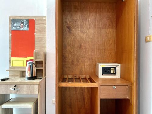 a small kitchen with a microwave on a wooden cabinet at Mini Thai Guesthouse Patong in Patong Beach
