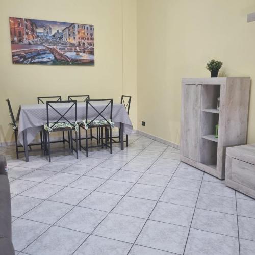 a dining room with a table and chairs on a tile floor at Casa Vanessa in Rome