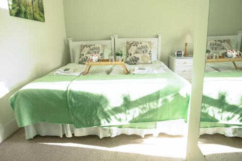a bedroom with two beds with green sheets at Hallmark Guest House in Aberdeen