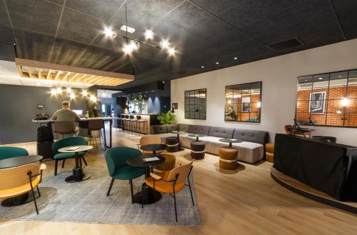 a lobby with tables and chairs and a bar at Campanile Prime Paris 19 - La Villette in Paris