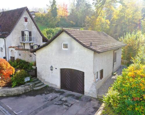 a large white house with a garage at peaceful tiny house near forest in Rorschacherberg
