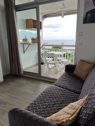 a living room with a couch and a view of the ocean at Lady laying in Le Diamant