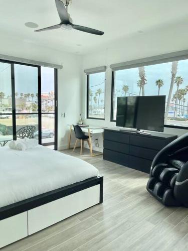 a bedroom with a bed and a flat screen tv at Beach House with Rooftop Jacuzzi in Huntington Beach