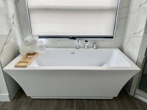 een witte wastafel in een badkamer met een spiegel bij Beach House with Rooftop Jacuzzi in Huntington Beach