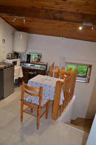 une cuisine et une salle à manger avec une table et des chaises dans l'établissement studio indépendant dans maison à la campagne, à Égliseneuve-près-Billom