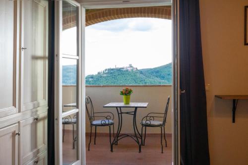 a balcony with a table and chairs and a window at Casale La Querce in Civitella in Val di Chiana