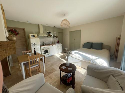 un salon avec un lit et une cuisine dans l'établissement Studio Le petit métayer, à Pommard