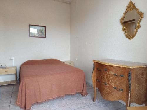 une chambre avec un lit et un miroir au mur dans l'établissement Appartement T2 Meublé avec Balcon, à Aire-sur-lʼAdour