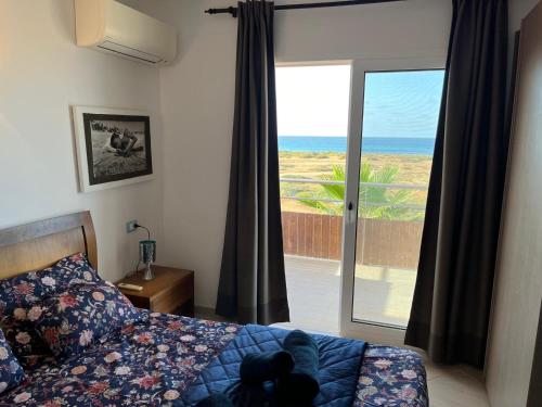 a bedroom with a bed and a view of the ocean at Bayview Bliss Appartement just 50 steps from the beach in Santa Maria
