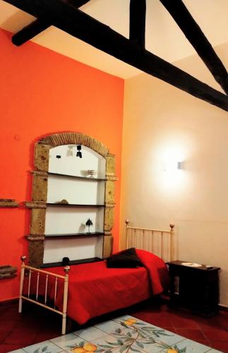 a bedroom with orange walls and a bed and a shelf at Black Stone in Pompei