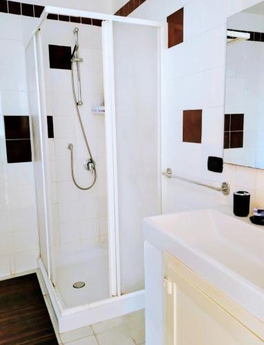 a white bathroom with a shower and a sink at Black Stone in Pompei