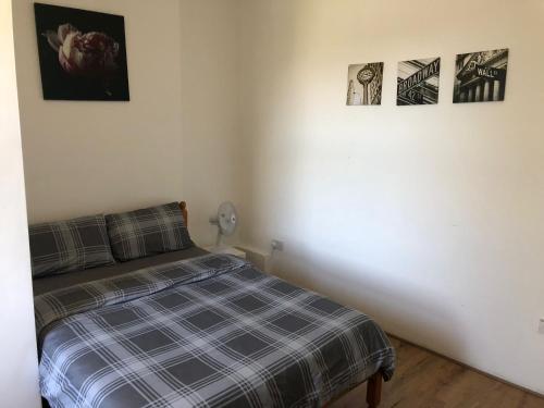 a bedroom with a bed and three pictures on the wall at London DM x Weekly Monthly x Deals in London