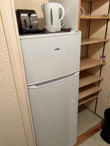 a refrigerator with a coffee maker on top of it at Le Corbier Soyouz Vanguard in Le Corbier