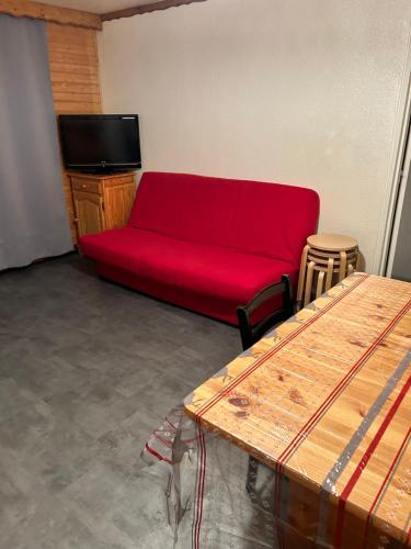 un salon avec un canapé rouge et une télévision dans l'établissement Le Corbier Soyouz Vanguard, au Corbier