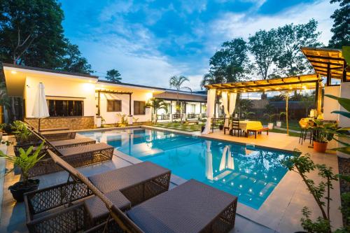 una piscina con mobili da giardino e una casa di Casa Arturo a Città di Puerto Princesa