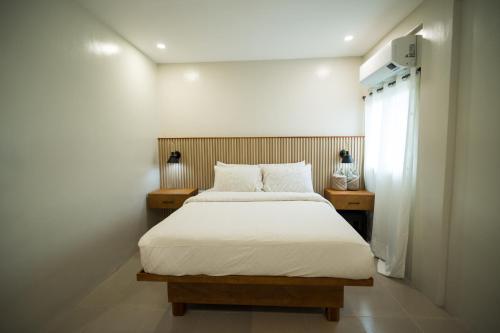 una camera da letto con un letto bianco e due comodini di Casa Arturo a Città di Puerto Princesa