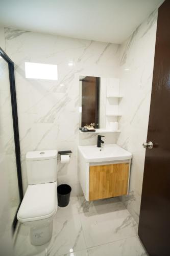un bagno bianco con un water e un lavandino di Casa Arturo a Città di Puerto Princesa