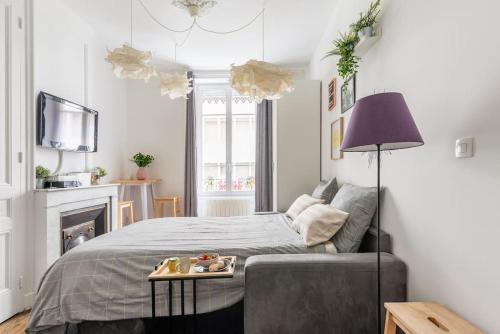 - une chambre avec un lit et une table avec un plateau dans l'établissement Appartement moderne et calme, à Lyon
