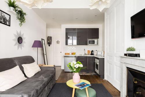 un salon avec un canapé et une cuisine dans l'établissement Appartement moderne et calme, à Lyon