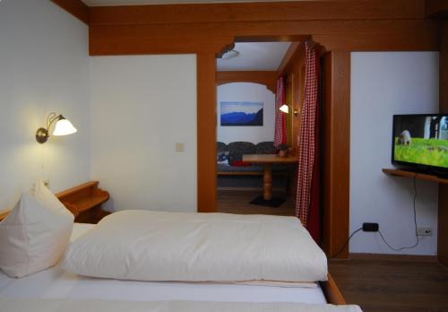 a bedroom with a bed and a flat screen tv at Alpenlodge Pfronten in Pfronten