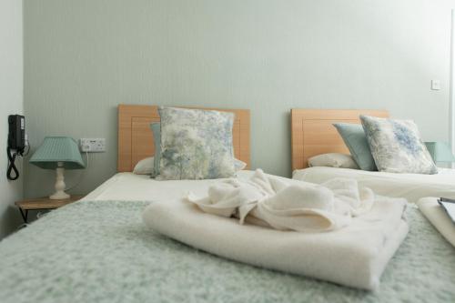 a bedroom with two beds with white towels on them at Tyn-y-Coed Inn in Betws-y-coed