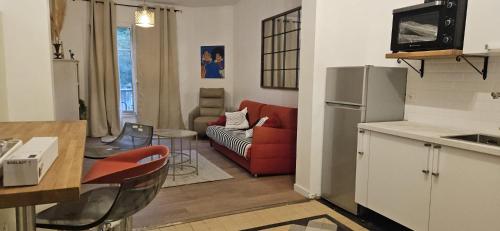 Il comprend une cuisine et un salon avec un canapé rouge. dans l'établissement Villa d athis, à Athis-Mons