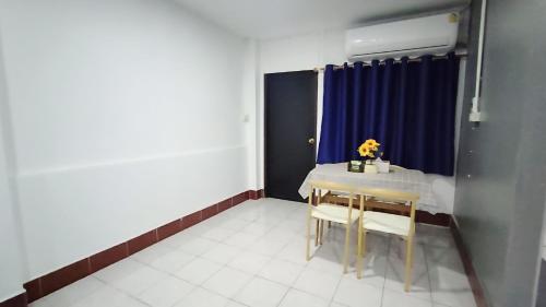a dining room with a table and a blue curtain at Apartment near Central Festival Hatyai in Hat Yai