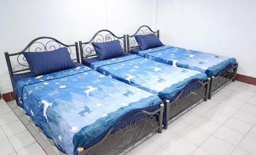 two beds sitting next to each other in a room at Apartment near Central Festival Hatyai in Hat Yai
