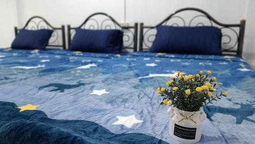 a bed with a vase of flowers on it at Apartment near Central Festival Hatyai in Hat Yai