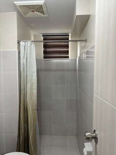 a bathroom with a shower and a toilet at Solana Tower 1 New and Very Neat Studio Unit near SM Manila in Manila