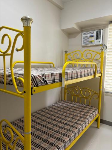 a bunk bed room with two bunk beds and a bench at Solana Tower 1 New and Very Neat Studio Unit near SM Manila in Manila