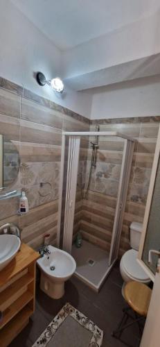 a bathroom with a shower and a toilet and a sink at Hotel Mondial 2 in Villasor
