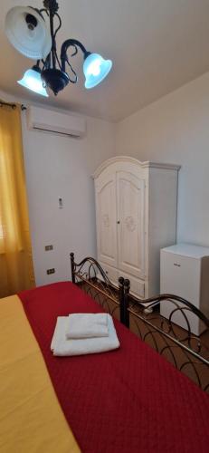 a room with a bed with a red blanket and a table at Hotel Mondial 2 in Villasor